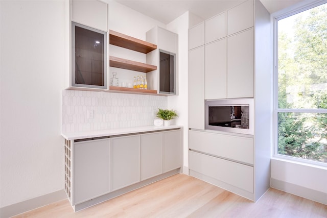 kitchen featuring open shelves, light wood-type flooring, light countertops, and modern cabinets