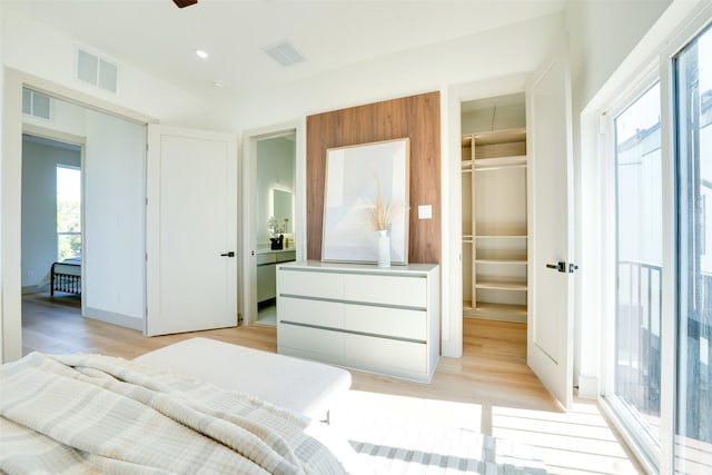 bedroom with light wood finished floors, a spacious closet, and visible vents