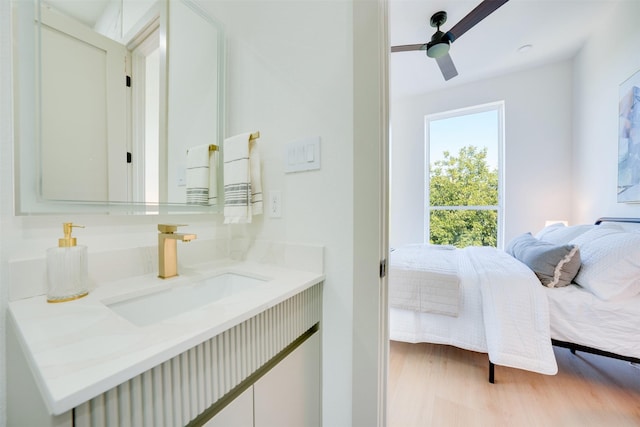 ensuite bathroom with ceiling fan, wood finished floors, connected bathroom, and vanity