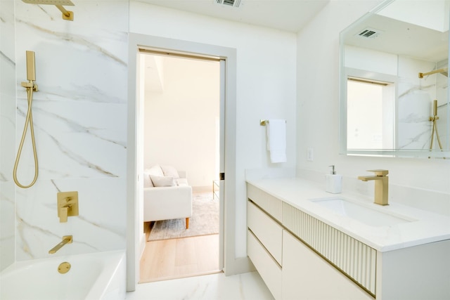 ensuite bathroom featuring a combined bath / shower with marble appearance, visible vents, vanity, and ensuite bathroom