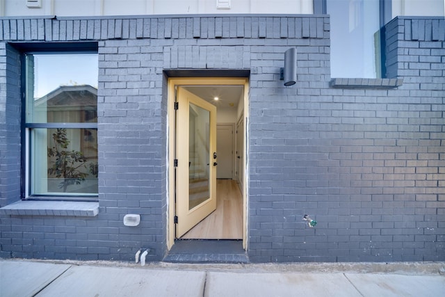 doorway to property with brick siding