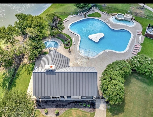 community pool featuring a patio, a lawn, and fence