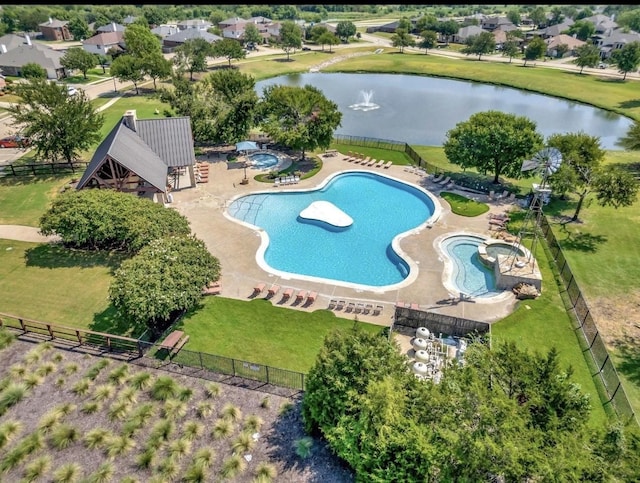 community pool with a water view and fence