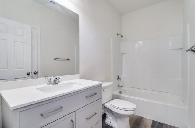 bathroom featuring toilet, wood finished floors, visible vents, vanity, and shower / bathing tub combination