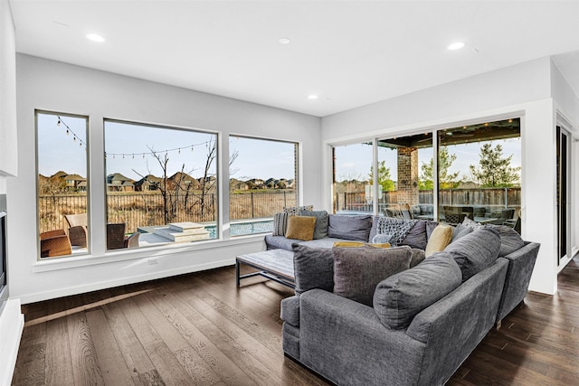 living room featuring dark wood finished floors, recessed lighting, and baseboards