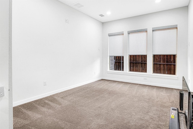 spare room with visible vents, baseboards, and carpet floors