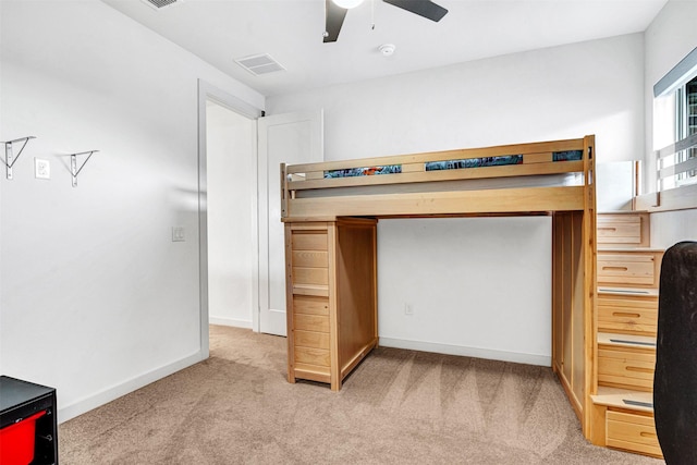 unfurnished bedroom with a ceiling fan, visible vents, baseboards, and light carpet