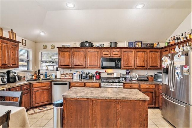 kitchen with stainless steel appliances, vaulted ceiling, light tile patterned flooring, and a sink