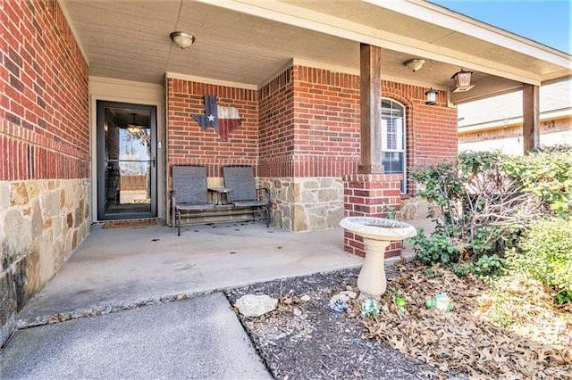 entrance to property featuring stone siding, a patio, and brick siding