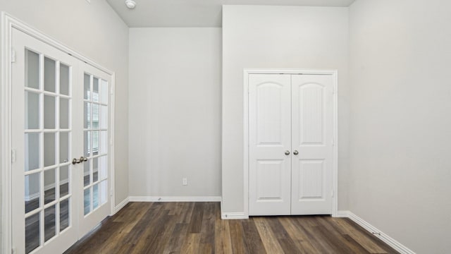 unfurnished bedroom featuring dark wood-style floors, french doors, and baseboards