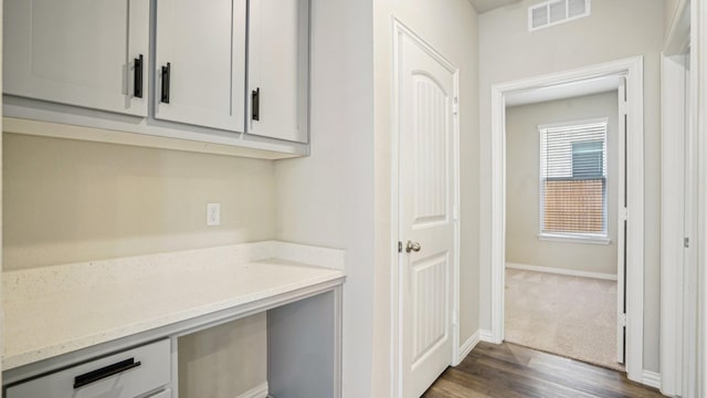 interior space featuring dark wood-style floors, visible vents, and baseboards