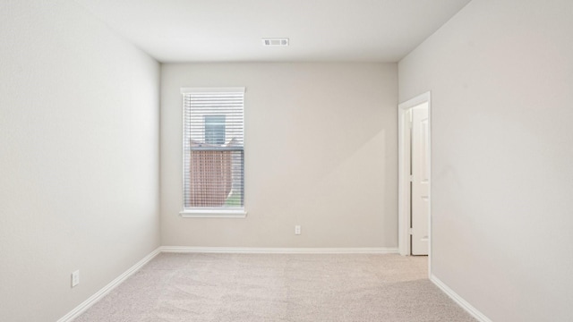 unfurnished room featuring light colored carpet, visible vents, and baseboards