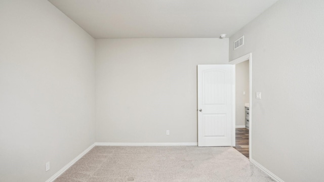 spare room with baseboards, visible vents, and carpet floors