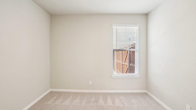 unfurnished room featuring light colored carpet and baseboards