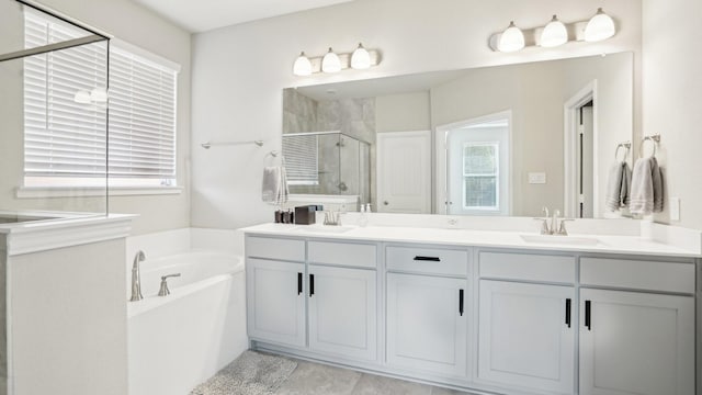 bathroom with a shower stall, a garden tub, double vanity, and a sink