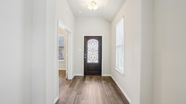 foyer entrance with vaulted ceiling, wood finished floors, visible vents, and baseboards