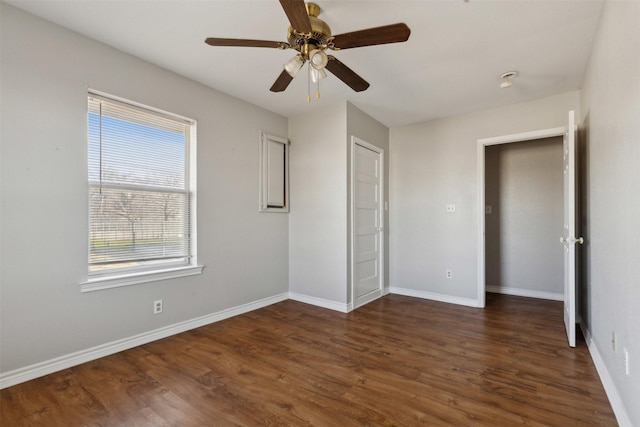 unfurnished bedroom with dark wood-type flooring, baseboards, and ceiling fan