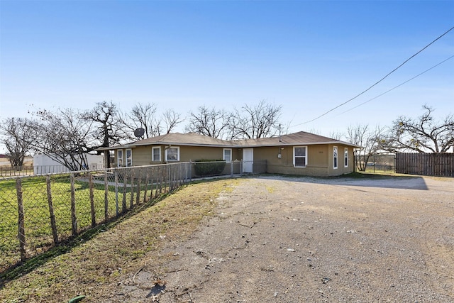 view of front of property with fence and dirt driveway