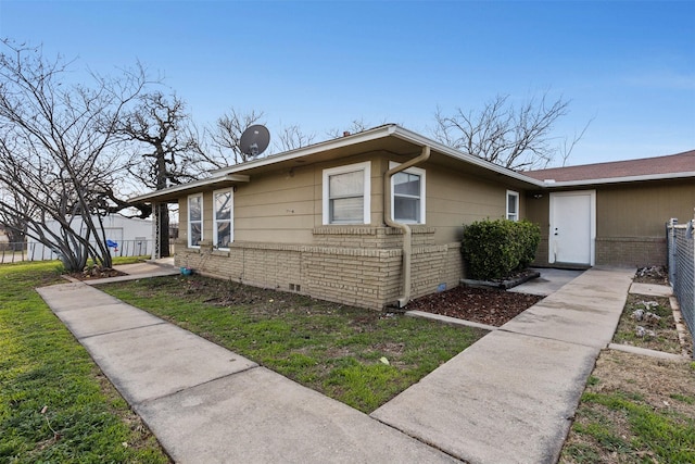 view of front facade featuring crawl space, a front lawn, brick siding, and fence