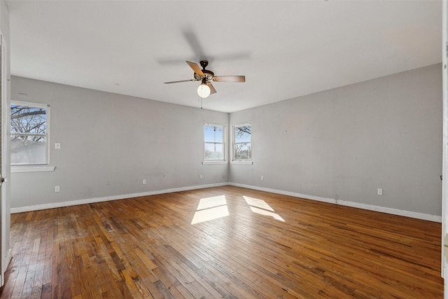 spare room with baseboards, wood-type flooring, and ceiling fan