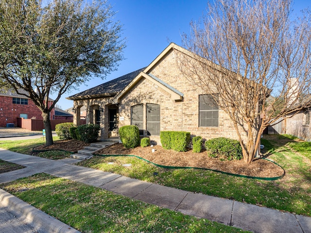 view of front of property featuring fence and brick siding