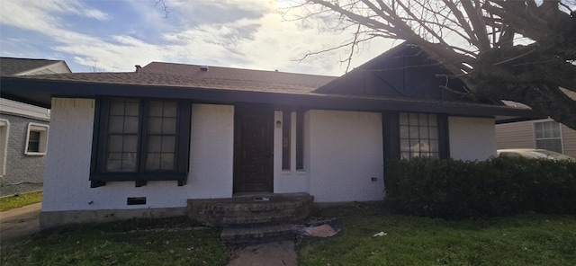 view of front facade featuring roof with shingles and crawl space