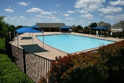 community pool featuring a patio and fence