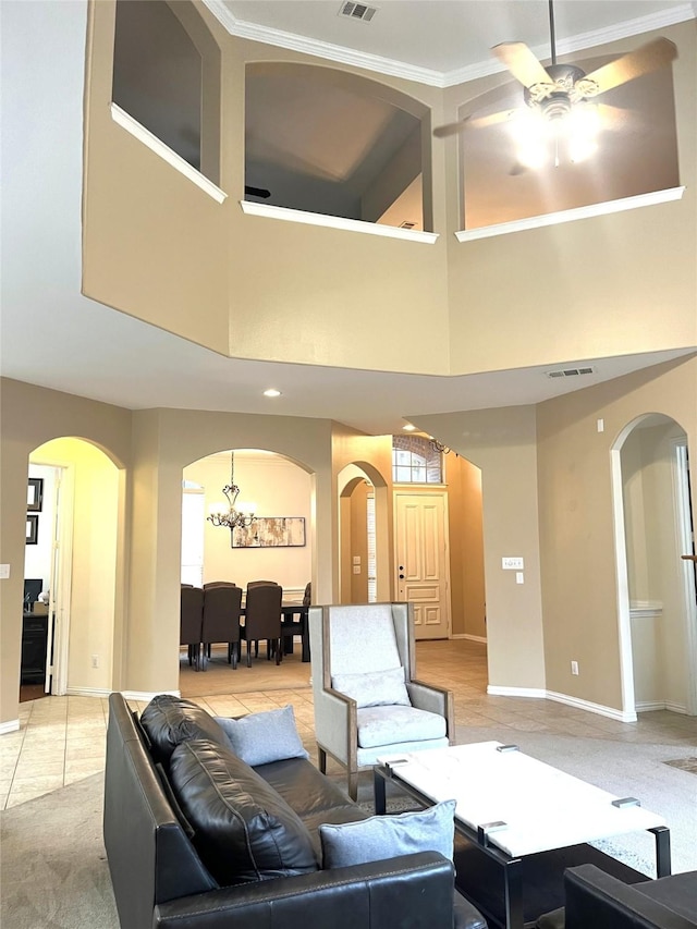 living area featuring light tile patterned floors, baseboards, visible vents, arched walkways, and ceiling fan