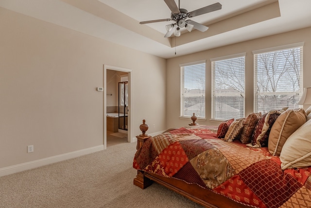 bedroom featuring carpet flooring, multiple windows, a raised ceiling, and baseboards