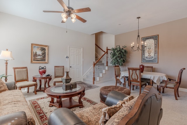 living room with baseboards, light carpet, stairs, and ceiling fan with notable chandelier