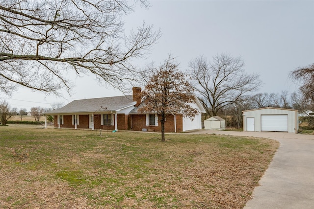 view of front of home with brick siding, a detached garage, a chimney, an outdoor structure, and a front lawn