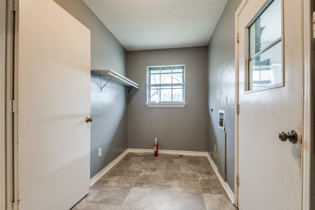 laundry room with laundry area, baseboards, hookup for a washing machine, a textured ceiling, and electric dryer hookup