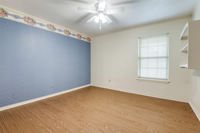 unfurnished room featuring a textured ceiling, ceiling fan, and wood finished floors