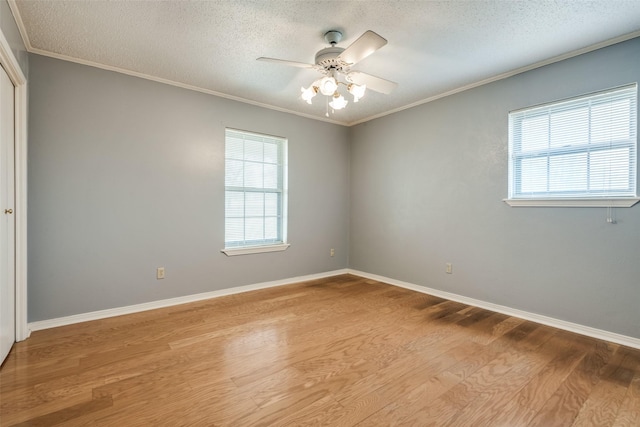 unfurnished room with a wealth of natural light, ornamental molding, and wood finished floors