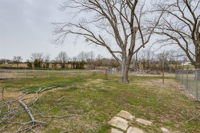 view of yard with fence and a rural view