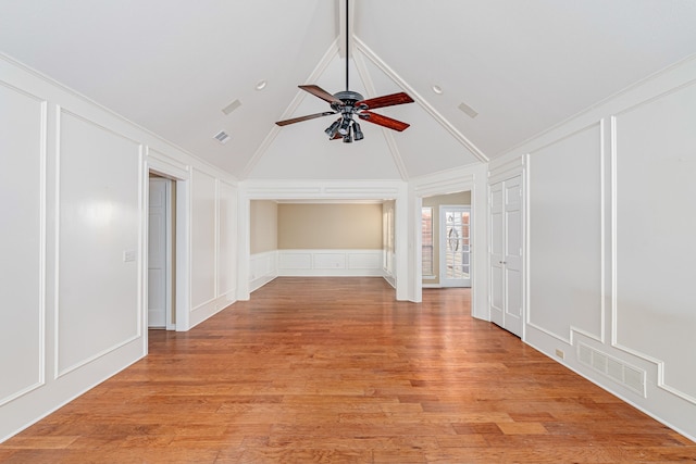 empty room featuring light wood-type flooring, visible vents, a decorative wall, and ceiling fan