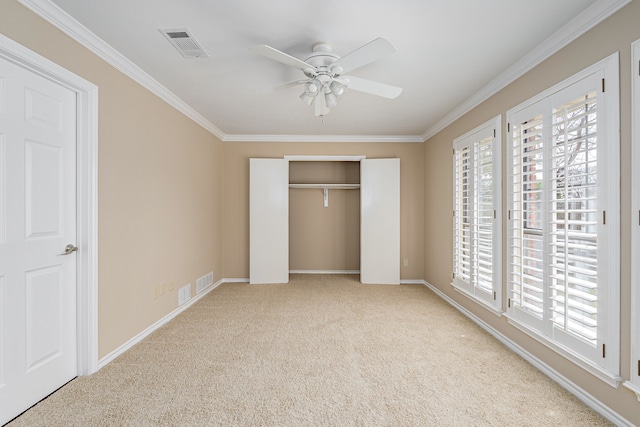 unfurnished bedroom with carpet, multiple windows, visible vents, and ornamental molding