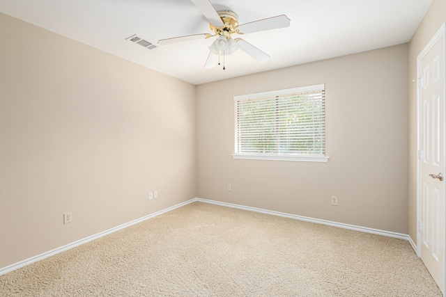 unfurnished room with a ceiling fan, visible vents, light carpet, and baseboards