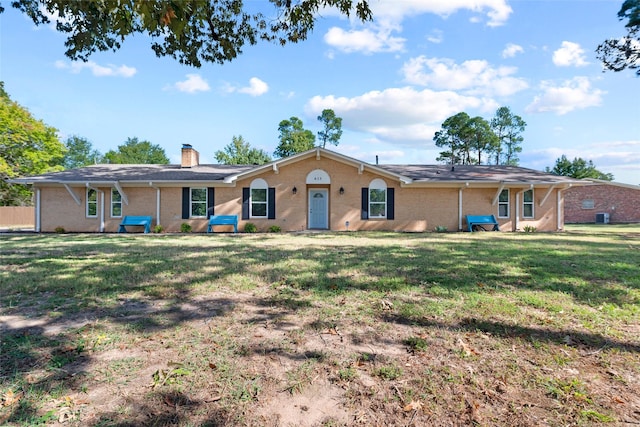 single story home featuring brick siding, a chimney, and a front lawn