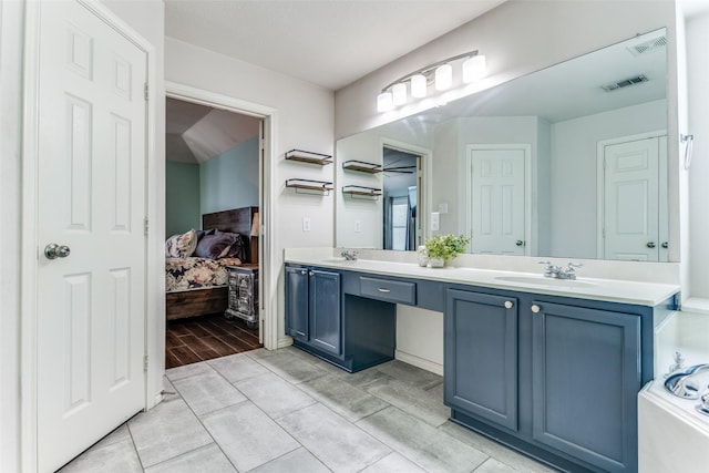 ensuite bathroom featuring visible vents, connected bathroom, and a sink