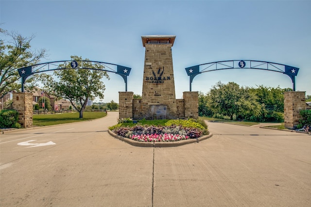 view of road featuring a gated entry and curbs