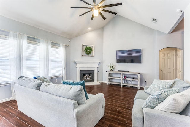 living area with arched walkways, plenty of natural light, and wood tiled floor