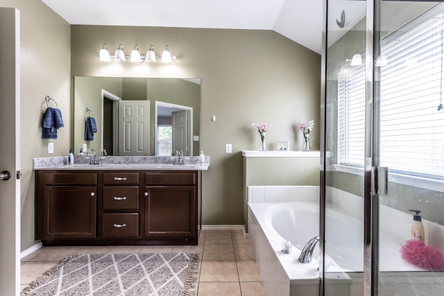 bathroom with double vanity, a bath, tile patterned flooring, vaulted ceiling, and a sink