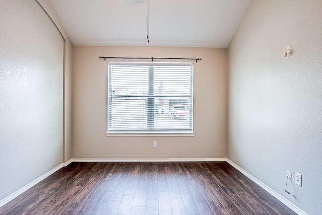 unfurnished room featuring dark wood-type flooring and baseboards