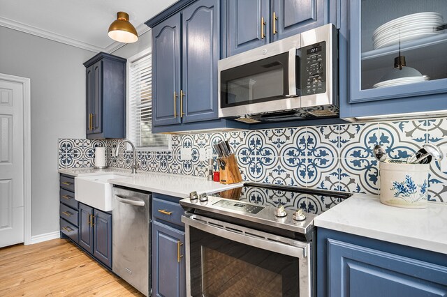 7811 Double Oaks Rd, Athens, TX 75752 - kitchen with appliances with stainless steel finishes, blue cabinetry, backsplash, a sink, and crown molding