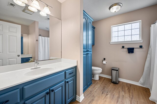 7811 Double Oaks Rd, Athens, TX 75752 - bathroom with toilet, vanity, baseboards, and wood finished floors