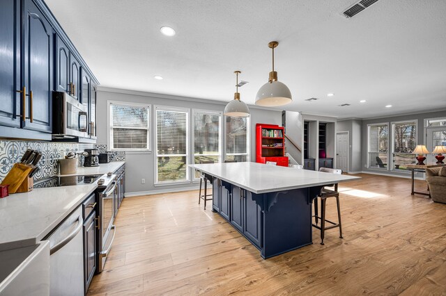 7811 Double Oaks Rd, Athens, TX 75752 - kitchen with appliances with stainless steel finishes, a kitchen bar, baseboards, recessed lighting, and light wood-style flooring