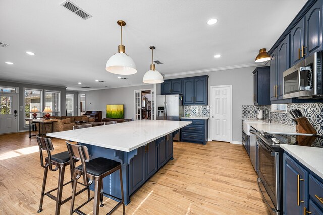 7811 Double Oaks Rd, Athens, TX 75752 - kitchen featuring appliances with stainless steel finishes, crown molding, light countertops, blue cabinetry, and a kitchen island