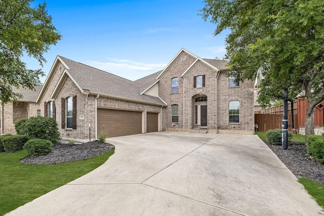 view of front facade featuring a garage, brick siding, fence, concrete driveway, and roof with shingles