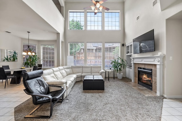 tiled living room with a fireplace, visible vents, and a wealth of natural light